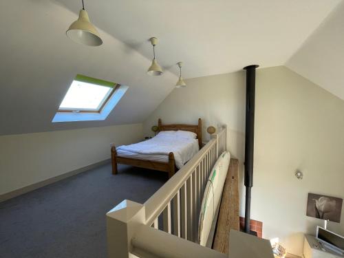 a attic bedroom with a bed and a window at Surf Shack 1-Bed Cottage Sleeps 2 Pet Friendly in Shorwell