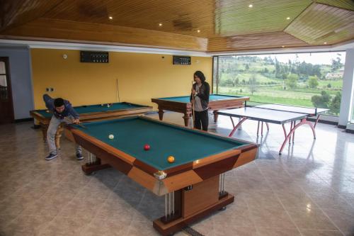 two people playing pool in a room with two tables at Lujosa Casa Quinta en Naturaleza Andina in Iza