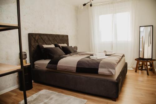 um quarto com uma cama grande e uma janela em Avenue apartment em Slavonski Brod