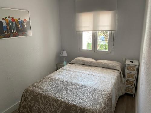 um pequeno quarto com uma cama e uma janela em Apartamento Dacosta em Plasencia
