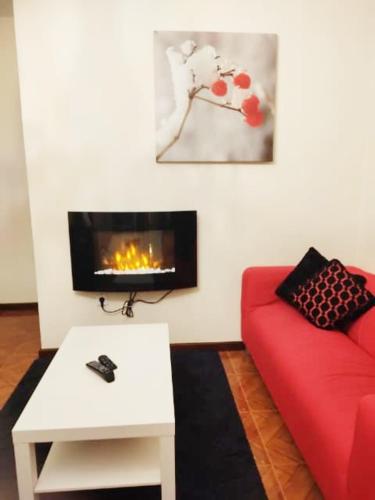 a living room with a red couch and a fireplace at Casa S. Félix in Arcos