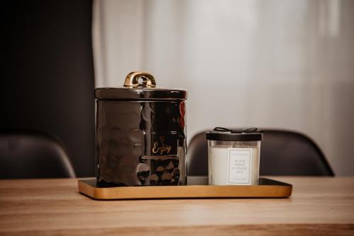 Una vela y un recipiente sobre una mesa de madera. en Avenue apartment, en Slavonski Brod