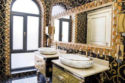 uma casa de banho com 2 lavatórios e um espelho grande em Level Hotel em Tashkent