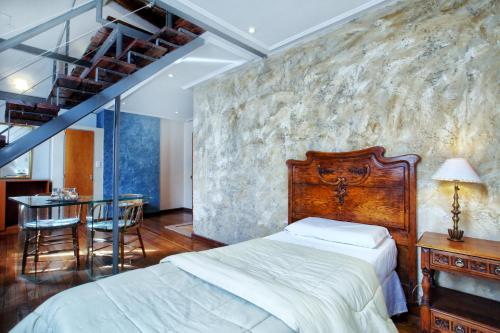 Schlafzimmer mit einem Bett und einem Tisch mit Stühlen in der Unterkunft La Fresque Hotel in Buenos Aires
