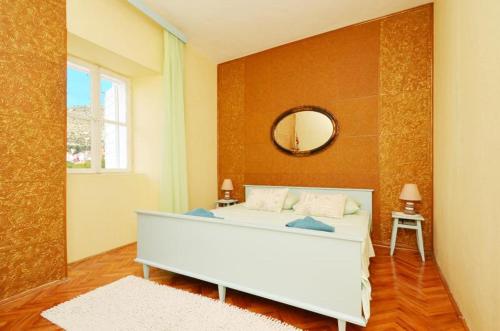 um quarto com uma cama branca e um espelho em Villa Marini dvori em Trogir