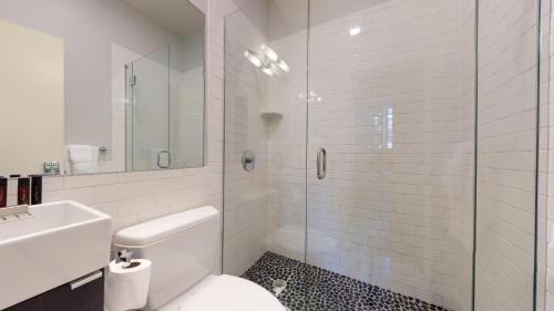 uma casa de banho com um WC e uma cabina de duche em vidro. em Charming Studio in Boston Brownstone, C. Ave #33 em Boston