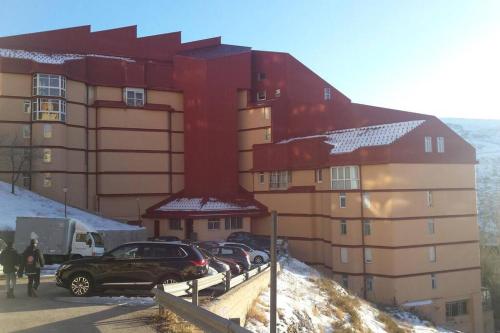 a large building with cars parked in front of it at Apartamento T28 Edif Europa y parking gratuito in Sierra Nevada
