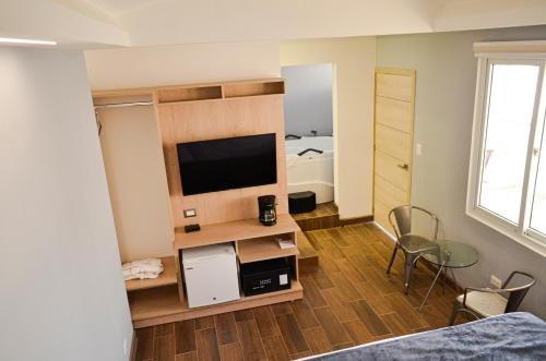 een woonkamer met een tv en een slaapkamer bij Casa Bella Boutique Hotel in Antigua Guatemala