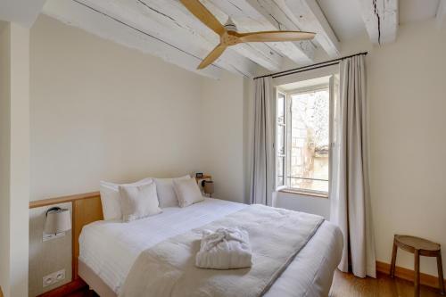 1 dormitorio con cama blanca y ventana en Badon Boutique Hotel, en Saint-Émilion