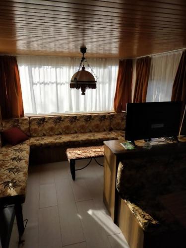 a living room with a couch and a window at ferme pedagogique des pennetieres in Montcorbon