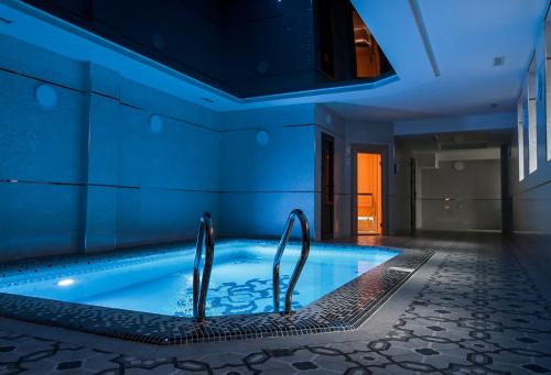- une piscine avec des lumières bleues dans une maison dans l'établissement Level Hotel, à Tachkent