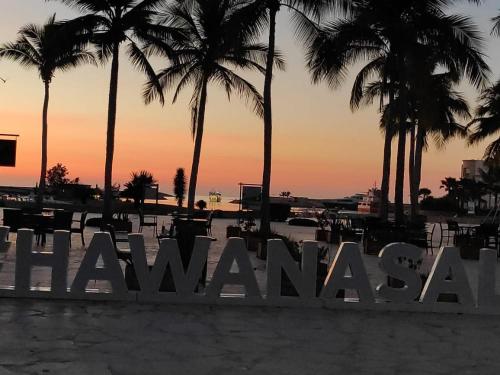 a sign on the beach with palm trees in the background at Segal Salalah-Forest Island-Hawana in Salalah