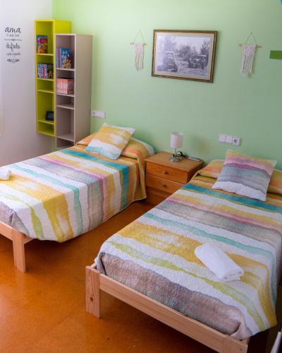 a bedroom with two beds and a book shelf at Villa Paquita - Delta de l'Ebre in Deltebre