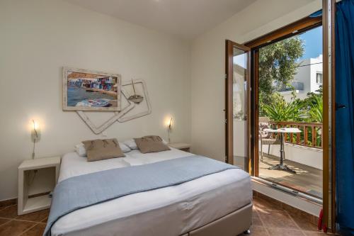 Un dormitorio con una cama y un balcón. en Medousa, en Adamas