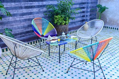 three chairs and a table on a patio at Riad Al mazhar in Rabat