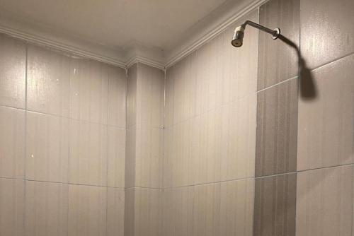 a shower with a shower head on a wall at RedDoorz Plus Syariah @ Jalan Syiah Kuala Banda Aceh in Lheue