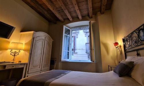 a bedroom with a bed and a window at Hotel Piazza Vecchia in Bergamo