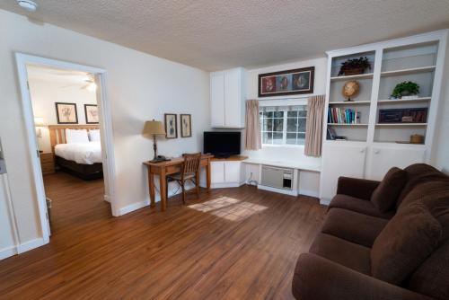 Cold Creek Inn في جبل شاستا: غرفة معيشة مع أريكة وطاولة وسرير