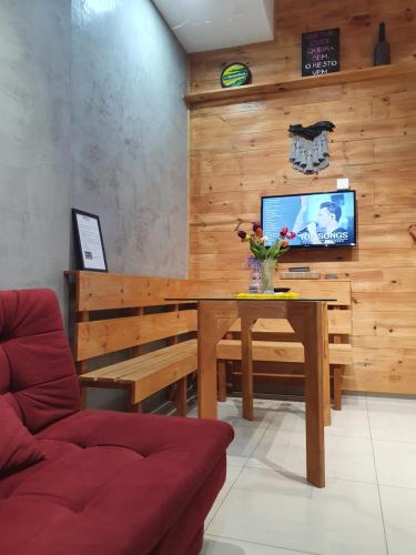 a living room with a table and a tv at Aconchego do Vale in Blumenau