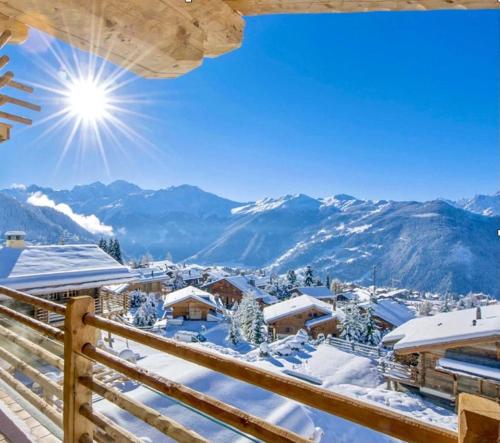 a winter view from the balcony of a lodge with snow covered mountains at New, Luxurious and Central Art Penthouse in Verbier