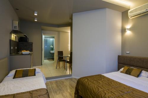 a hotel room with two beds and a kitchen at Appartamenti Astoria in Bologna