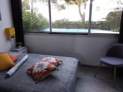 une chambre avec un lit avec un oreiller et une fenêtre dans l'établissement Port Vincent, à La Grande Motte