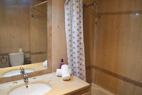 a bathroom with a sink and a shower at Alvor Marachique Duplex in Alvor
