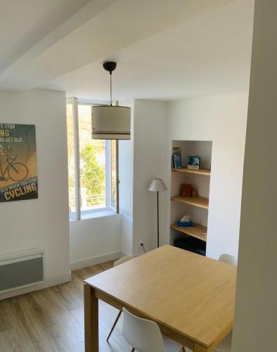 une salle à manger avec une table en bois et une fenêtre dans l'établissement Appartement Luz Saint Sauveur / Tourmalet, à Luz-Saint-Sauveur