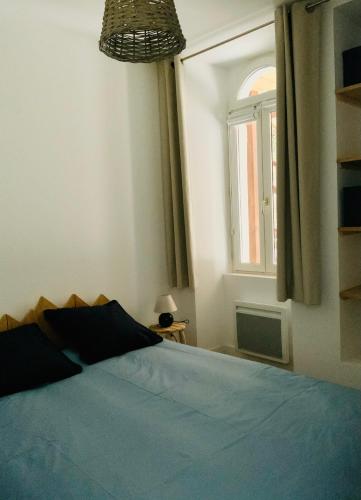 une chambre avec un lit bleu et une fenêtre dans l'établissement Appartement Luz Saint Sauveur / Tourmalet, à Luz-Saint-Sauveur