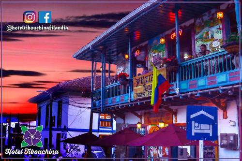 a building with a balcony with a flag and umbrellas at Hotel Tibouchina in Filandia