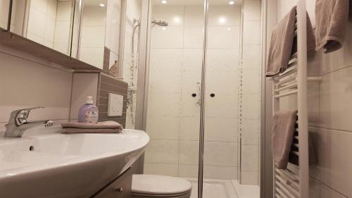 ein Bad mit einem Waschbecken, einem WC und einer Dusche in der Unterkunft FeWo Aust in Sankt Peter-Ording