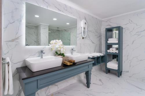 a bathroom with a sink, mirror, and bathtub at Oz Hotels Antalya Resort & Spa Adult 9 in Antalya