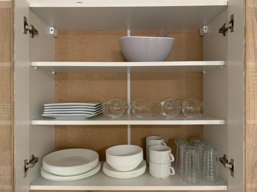 a cabinet filled with plates and bowls and dishes at Formidable Studio au cœur historique de Fréjus in Fréjus