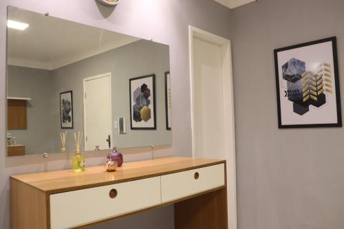 a bathroom with a vanity and a large mirror at Apartamento pelourinho salvador in Salvador