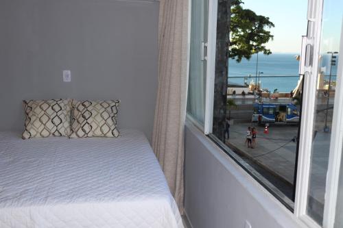 a bed on a balcony with a view of the ocean at Apartamento pelourinho salvador in Salvador