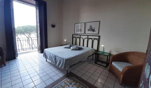 a bedroom with a bed and a chair and a window at casa Calla in Maiori