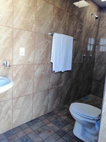 a bathroom with a toilet and a sink at Hotel Chely in Bernal