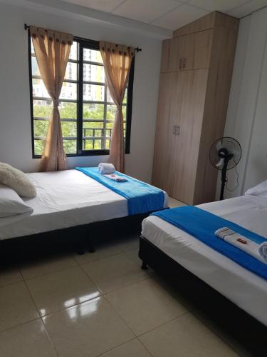 a bedroom with two beds and a window at Apartamentos Williams in Santa Rosa de Cabal