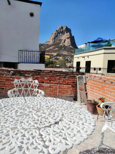 a patio with a table and chairs and a mountain at Hotel Chely in Bernal