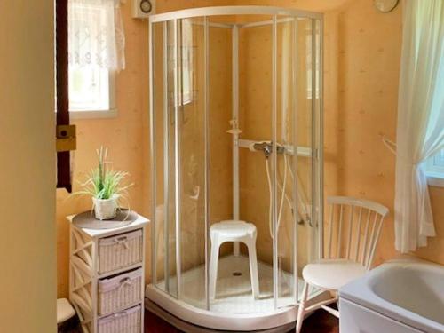 a shower with a chair and a stool in a bathroom at Holiday home Austefjorden in Austefjorden