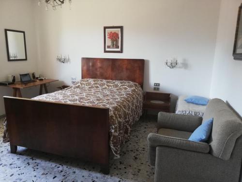 a bedroom with a bed and a couch and a chair at Pratomagno Apartment in Cetica