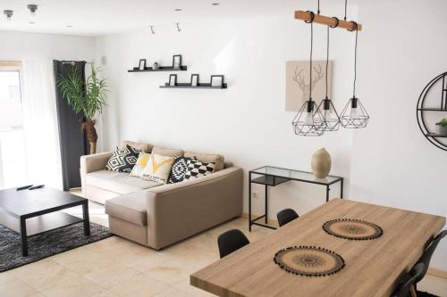 a living room with a table and a couch at Bay Residence Apartamento - Piscina in São Martinho do Porto