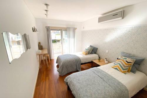 a bedroom with two beds and a window at Bay Residence Apartamento - Piscina in São Martinho do Porto