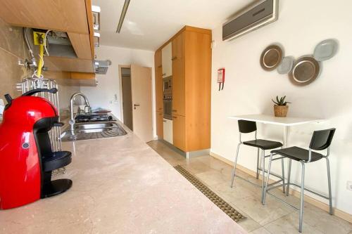 a kitchen with a red inflatable object next to a table at Bay Residence Apartamento - Piscina in São Martinho do Porto