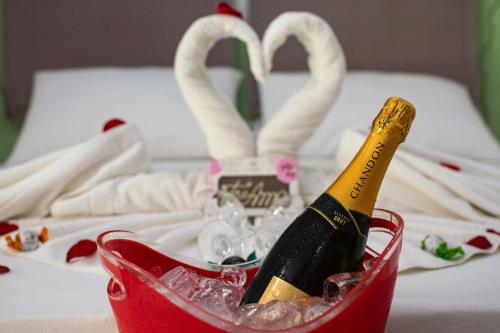 a bottle of champagne in a red basket on a table at Pousada do Tenório in Ubatuba