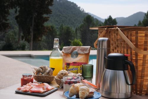 een tafel met een ontbijt van brood en jus d'orange bij Apartamentos Cortijo Peñardera in Siles