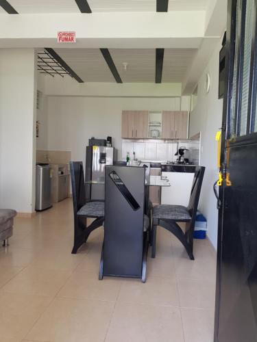 a room with a kitchen with chairs and a table at Apartamentos Williams in Santa Rosa de Cabal