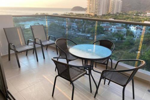 a table and chairs on a balcony with a view at Samaria Club de Playa! Salida directa al mar! Pozos Colorados, diversión para niños y grandes in Santa Marta