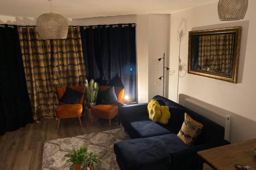 a living room with a blue couch and a table at Luxury Modern 2Bed Seafront Apartment in Rhos on Sea in Colwyn Bay