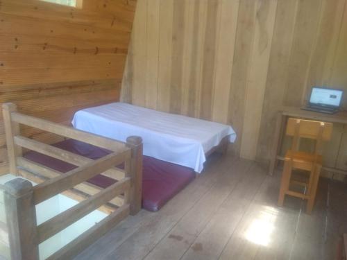 a small bedroom with a bed and a table at LANDE Tiny in Rantepao